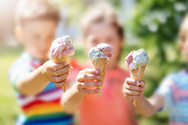 Group of children in the park eating cold ice cream.