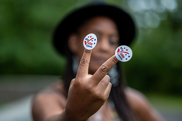 Woman holding stickers on her hand that say 